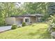 Modern home featuring a flat roof, covered parking, and lush landscaping with flowering shrubs at 220 Glenhill Ln, Chapel Hill, NC 27514