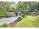 Striking home exterior with natural surroundings, modern design, and spacious driveway, highlighting privacy and style at 220 Glenhill Ln, Chapel Hill, NC 27514