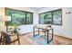 Bright office space with two large windows overlooking lush greenery, stylish rug, and modern desk and chair at 220 Glenhill Ln, Chapel Hill, NC 27514