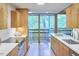 Well-lit kitchen boasts stylish cabinets, modern appliances, and a wall of windows with views of lush greenery at 220 Glenhill Ln, Chapel Hill, NC 27514
