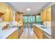 Galley kitchen featuring sleek wooden cabinets, white countertops, and large windows showcasing the surrounding greenery at 220 Glenhill Ln, Chapel Hill, NC 27514