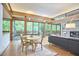 Open living and dining space with large glass doors, wood beamed ceiling, and stylish furniture at 220 Glenhill Ln, Chapel Hill, NC 27514
