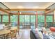Bright living room featuring walls of glass doors, beamed ceilings, and modern furnishings at 220 Glenhill Ln, Chapel Hill, NC 27514