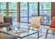 Modern living room featuring a glass coffee table, stylish seating, and a view to the outside deck at 220 Glenhill Ln, Chapel Hill, NC 27514