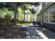 Lush backyard featuring mature trees, a wood fence, stone accents, and a cozy deck area at 221 Ironwoods Dr, Chapel Hill, NC 27516