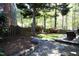 Tranquil backyard with a stone pathway, wooden deck, privacy fence, and mature trees at 221 Ironwoods Dr, Chapel Hill, NC 27516