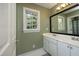 Bathroom featuring green walls, double sink, a window, and a mirror at 221 Ironwoods Dr, Chapel Hill, NC 27516