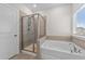 Bright bathroom features a shower with glass doors and a large tub at 2215 Montebell View Dr, Fuquay Varina, NC 27526