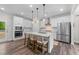 Modern kitchen featuring white cabinets, a spacious island with seating, and stainless steel appliances at 2215 Montebell View Dr, Fuquay Varina, NC 27526