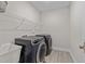 Laundry room with modern washer and dryer units and shelving for storage at 2215 Montebell View Dr, Fuquay Varina, NC 27526