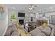 Open-concept living space features a comfortable sectional sofa, fireplace, and seamless flow to the kitchen at 2215 Montebell View Dr, Fuquay Varina, NC 27526