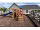 Community playground with wooden structure, slide, and climbing features on a mulch surface, perfect for Gathering fun at 2215 Montebell View Dr, Fuquay Varina, NC 27526