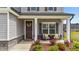 Inviting porch seating area with decorative floral arrangements, creating a warm and welcoming entry at 2215 Montebell View Dr, Fuquay Varina, NC 27526