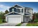 Charming two-story home featuring a two-car garage, light gray siding, and attractive blue accents at 2410 Abbot Hall Dr, Raleigh, NC 27616
