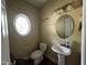 Powder room featuring a circular window, pedestal sink, and toilet at 249 Finley Ct, Clayton, NC 27520