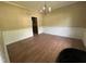 Empty dining room featuring hardwood floors, chandelier, and views into the kitchen at 249 Finley Ct, Clayton, NC 27520