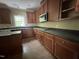 Kitchen featuring wood cabinets, dark countertops, and natural light at 249 Finley Ct, Clayton, NC 27520