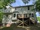 Back of the home featuring a wooden deck and stairs, siding, windows and brick foundation at 249 Finley Ct, Clayton, NC 27520