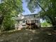Back of the home with a wooden deck and stairs, siding, windows and large, treed yard at 249 Finley Ct, Clayton, NC 27520
