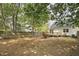Scenic backyard featuring mature trees, a wooden fence, and a glimpse of the home's exterior, creating a private oasis at 2611 Sawmill Rd, Raleigh, NC 27613