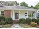 Inviting single-story home featuring a covered front porch, brick accents, and professionally landscaped grounds at 2611 Sawmill Rd, Raleigh, NC 27613