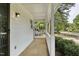 Side view of the front porch with white columns and stone flooring that offers curb appeal at 2611 Sawmill Rd, Raleigh, NC 27613