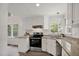 Well-lit kitchen with stainless steel range, granite countertops, and a view from a window at 2611 Sawmill Rd, Raleigh, NC 27613