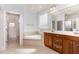 Bright bathroom featuring a corner tub, double vanity with wood cabinets, and tile flooring at 2821 Penfold Ln, Wake Forest, NC 27587