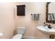 Elegant powder room featuring pedestal sink, decorative mirror, and fixtures at 2821 Penfold Ln, Wake Forest, NC 27587