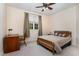 Bedroom featuring a ceiling fan, large window, desk and chair, bedside tables, and warm natural light at 2821 Penfold Ln, Wake Forest, NC 27587