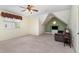 Spacious bonus room with neutral walls, ceiling fan and a comfortable armchair; lots of natural light at 2821 Penfold Ln, Wake Forest, NC 27587