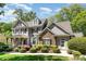 Attractive two-story home featuring a stone facade, covered porch, and lush landscaping on a sunny day at 2821 Penfold Ln, Wake Forest, NC 27587