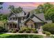 Attractive two-story home featuring a stone facade, covered porch, and lush landscaping on a sunny day at 2821 Penfold Ln, Wake Forest, NC 27587