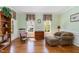 Bright sitting room featuring hardwood floors, multiple windows, and classic furnishings at 2821 Penfold Ln, Wake Forest, NC 27587