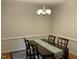 Dining room table with decorative runner and a modern chandelier with lighting at 3648 Sleepy Hollow, Wake Forest, NC 27587