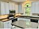 White kitchen with stainless steel microwave and sink with a view to the outside at 3648 Sleepy Hollow, Wake Forest, NC 27587