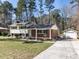Charming home with a brick facade, light siding, and a spacious front yard surrounded by mature trees at 3818 Hillgrand Dr, Durham, NC 27705