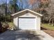 Exterior view of garage with a white door and concrete driveway, providing parking and storage at 3818 Hillgrand Dr, Durham, NC 27705
