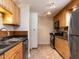 Galley kitchen with wooden cabinets, stainless steel appliances, and tile flooring at 3818 Hillgrand Dr, Durham, NC 27705