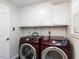 Laundry room features cabinets and modern red Samsung washer and dryer units at 3818 Hillgrand Dr, Durham, NC 27705