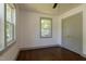 Bright bedroom with hardwood floors, fresh paint, and windows offering peaceful views of the outdoors at 408 E Maynard Ave, Durham, NC 27704
