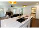Kitchen island with a sink and gold faucet, with a view of the living room and fireplace at 408 E Maynard Ave, Durham, NC 27704