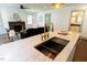 Kitchen island with a sink and gold faucet, with a view of the living room and fireplace at 408 E Maynard Ave, Durham, NC 27704
