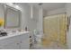 Bright bathroom with a single vanity, a mirror, and a yellow floral shower curtain at 4137 Lofty Ridge Pl, Morrisville, NC 27560