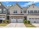 Charming townhome featuring a brick facade, a two-car garage, and beautifully landscaped front yard at 4137 Lofty Ridge Pl, Morrisville, NC 27560