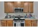Bright kitchen with a stainless steel oven and microwave, granite countertops and wood cabinets at 4137 Lofty Ridge Pl, Morrisville, NC 27560