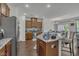 Well-lit kitchen features an island with granite countertops, stainless steel appliances and wood cabinets at 4137 Lofty Ridge Pl, Morrisville, NC 27560