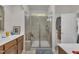 Bathroom shower with glass doors, tile surround, and built-in shelving for toiletries at 4137 Lofty Ridge Pl, Morrisville, NC 27560