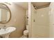 A charming bathroom featuring a walk-in shower, toilet, pedestal sink, and mirrored medicine cabinet at 414 N Cypress St, Wendell, NC 27591