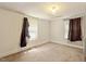 This light-filled bedroom offers plush carpeting, ample natural light, and neutral paint at 414 N Cypress St, Wendell, NC 27591
